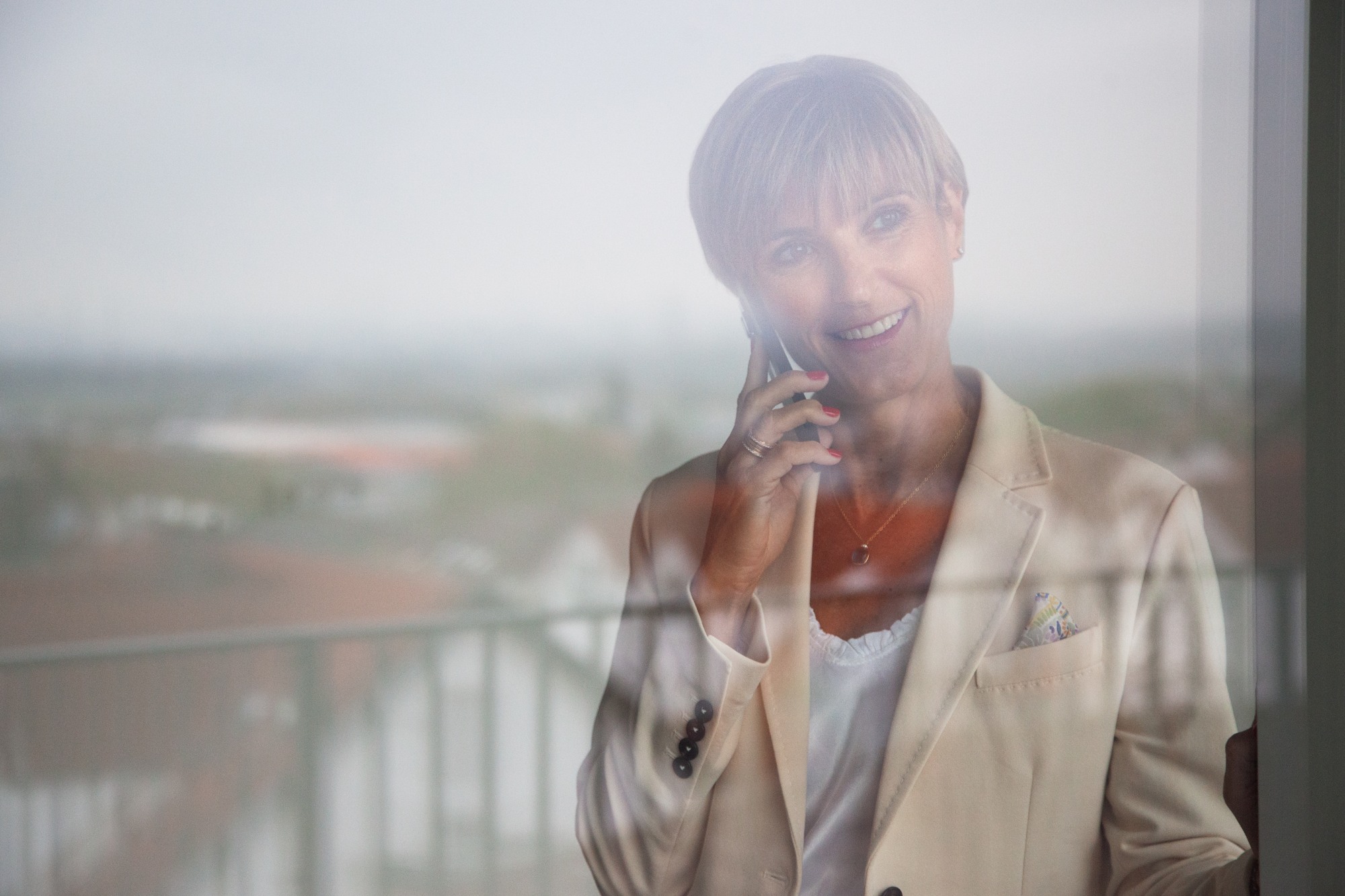 Tanja Wiese, Mitinhaberin der Wiese Immobilien GmbH, im Telefongespräch am Fenster